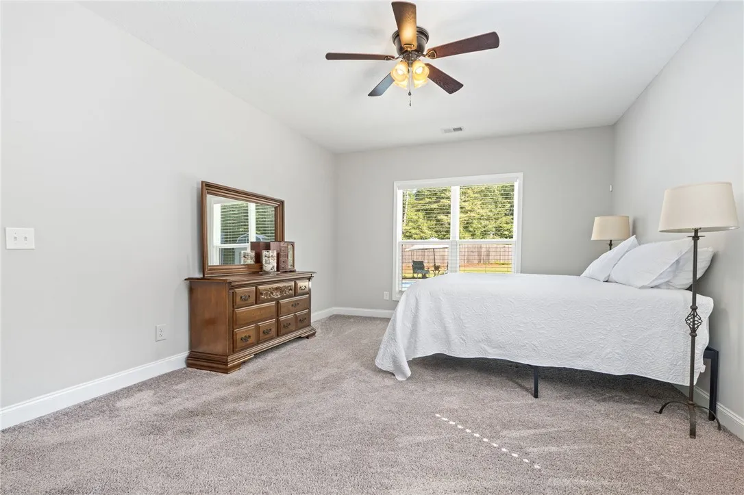A well-lit bedroom provides ample space and a pleasant view of the outdoors.