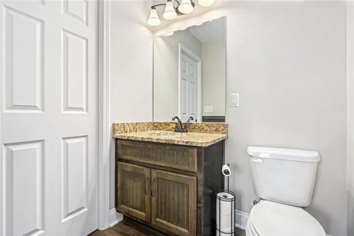 A well-appointed powder room features a granite-topped vanity and a clean, functional design.