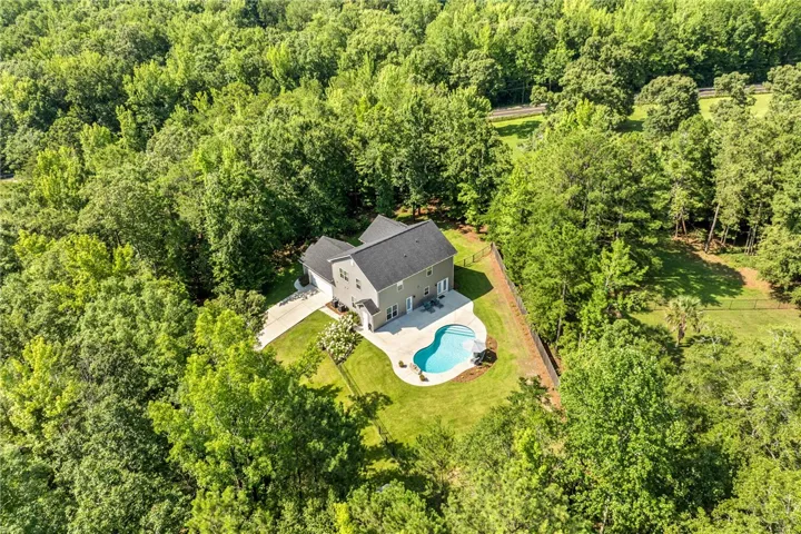 Perched amidst a verdant landscape, this private oasis features a sparkling in-ground pool.