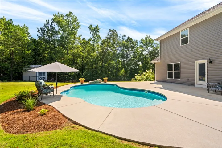 A private swimming pool and expansive patio area beckon for outdoor enjoyment.