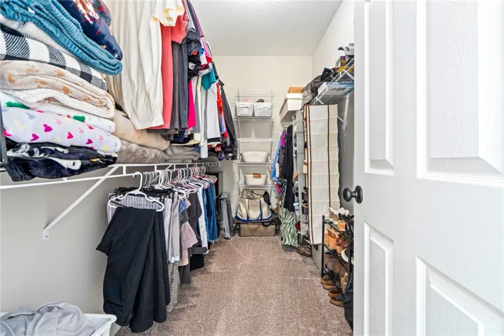 Customized storage solutions and ample hanging space create an organized walk-in closet.