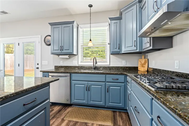 A well-appointed kitchen showcasing elegant blue cabinetry paired with lustrous granite countertops.