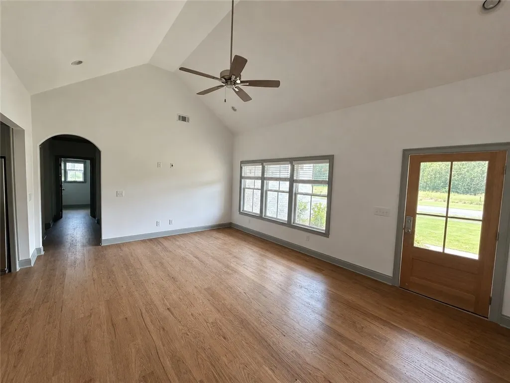 A spacious living area with soaring vaulted ceilings and natural wood flooring.