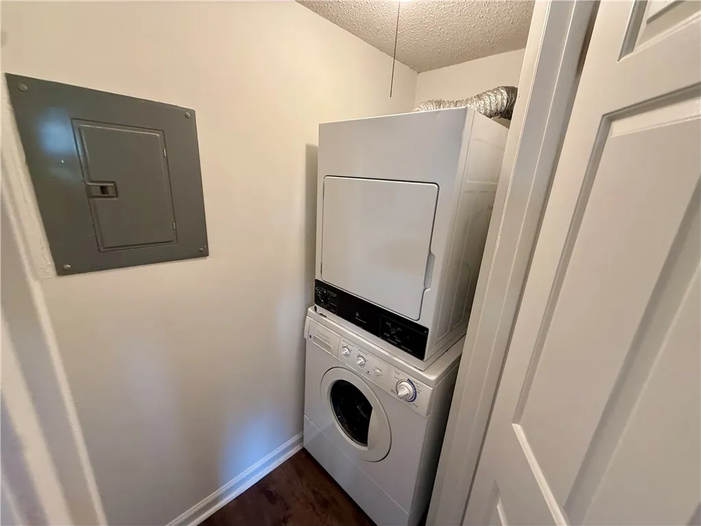 A dedicated laundry closet offers convenient, stacked washer and dryer units.