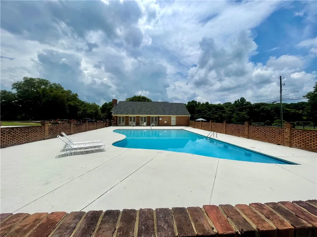 A private pool with a brick surround, offering a refreshing retreat alongside a classic residence.