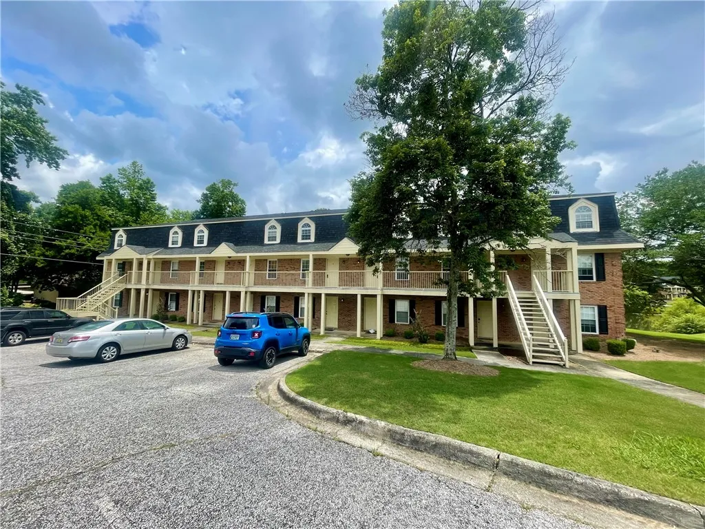 Multi-level residential building offers convenient access from shared balconies and ample outdoor parking.