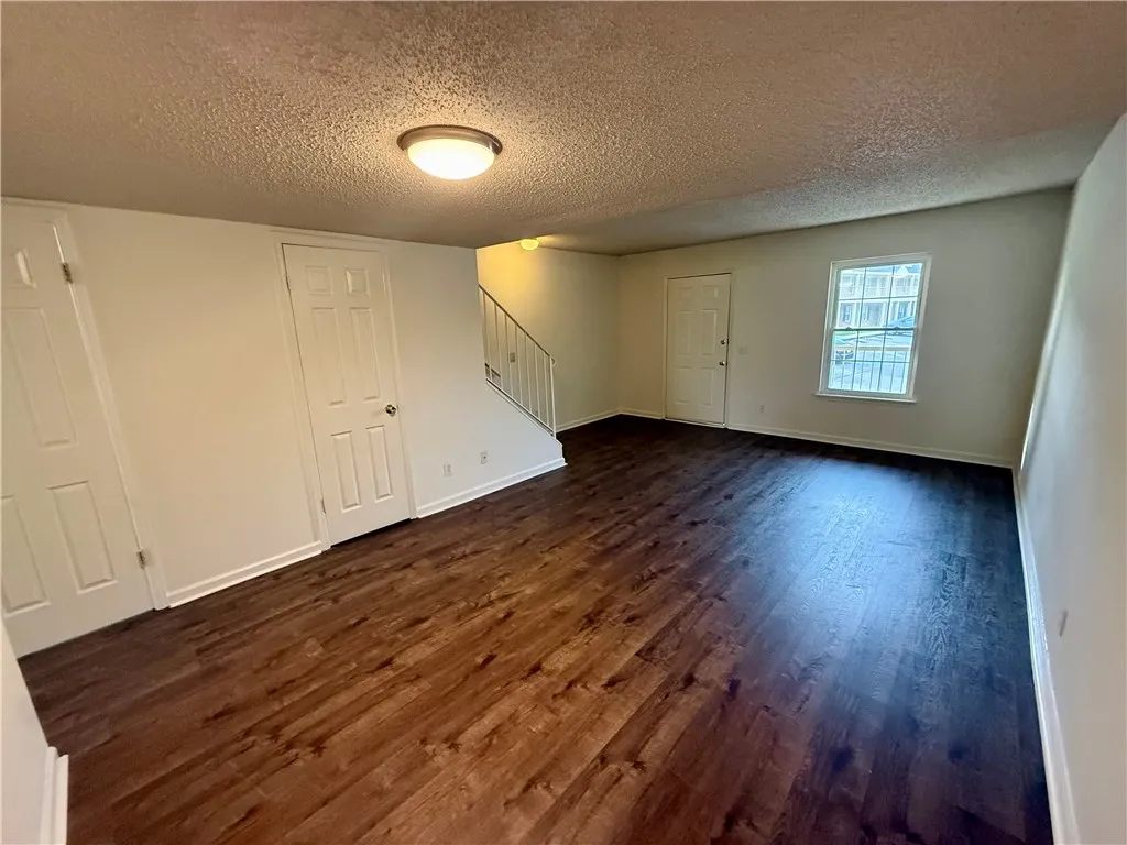 Hardwood flooring extends throughout this versatile living space, perfect for any layout.