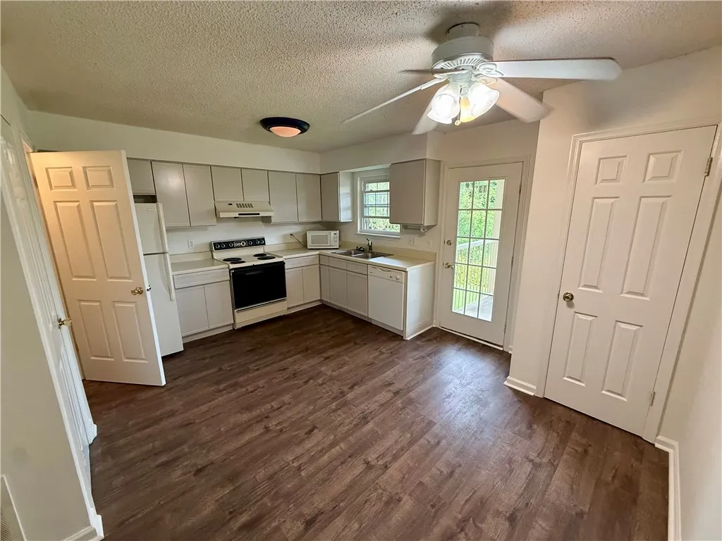 A well-equipped kitchen features a suite of appliances and direct outdoor access.