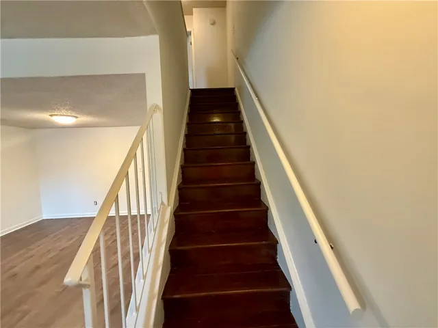 A dark wood staircase ascends, offering a transition between two distinct living levels.