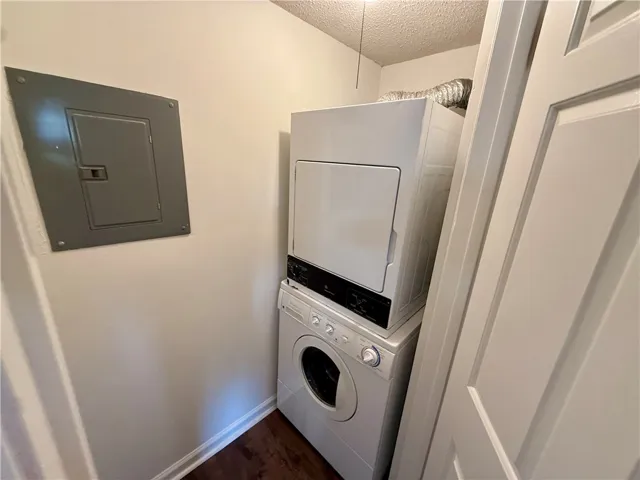 A dedicated laundry closet offers convenient, stacked washer and dryer units.