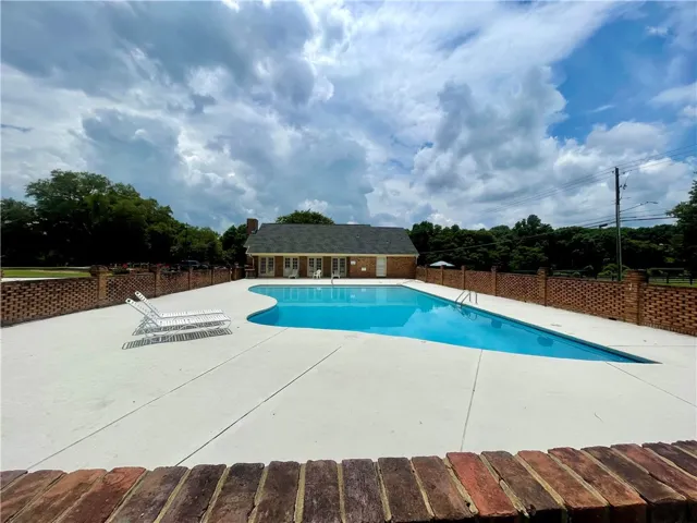 A private pool with a brick surround, offering a refreshing retreat alongside a classic residence.