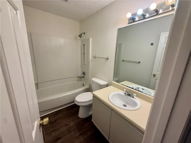 Functional full bathroom featuring a tub and shower combination with a single vanity.