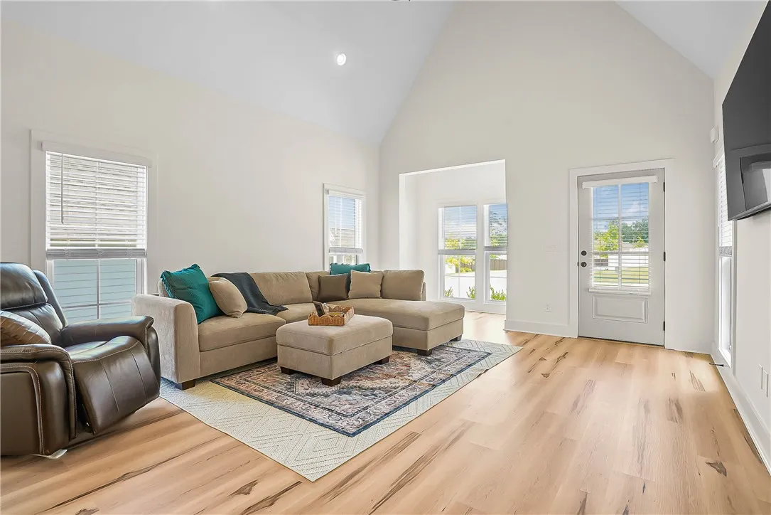 Living room features lots of windows with vaulted ceiling
