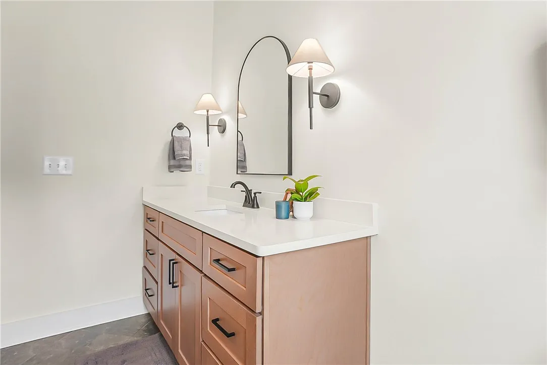 A refined bathroom vanity featuring a clean countertop, integrated sink, and modern lighting fixtures.