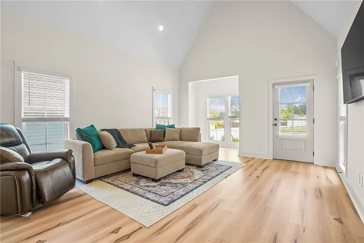 Living room features lots of windows with vaulted ceiling