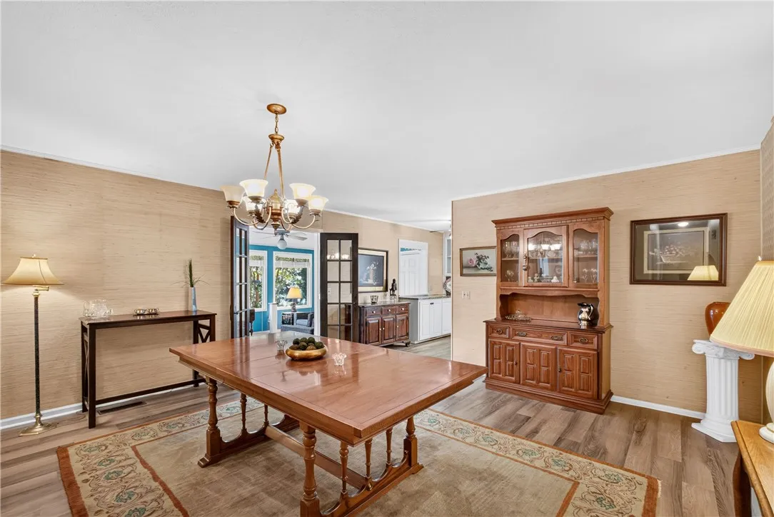 A classic dining area showcases ample space for entertaining, complemented by warm wood tones and elegant French doors.