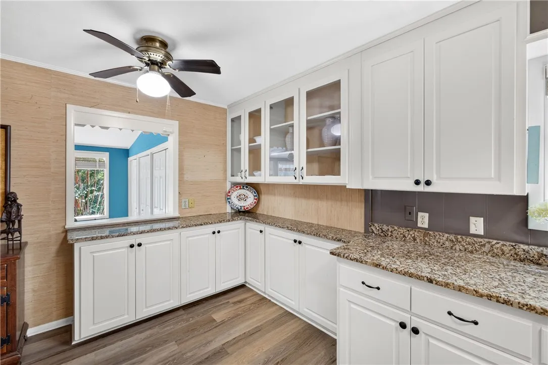 Granite counters and pristine white cabinetry define this well-appointed culinary space.
