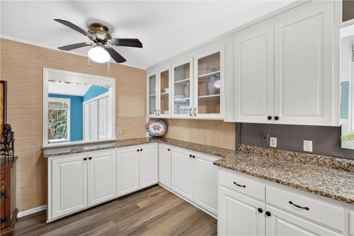 Granite counters and pristine white cabinetry define this well-appointed culinary space.