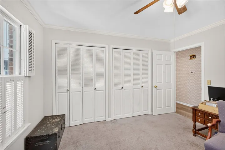 Plenty of storage with dual bi-fold closet doors complements this versatile room, bathed in natural light from the shuttered window.
