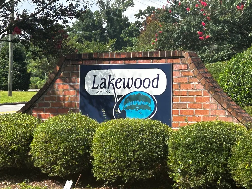 A welcoming brick sign framed by lush landscaping greets residents to Lakewood Commons.