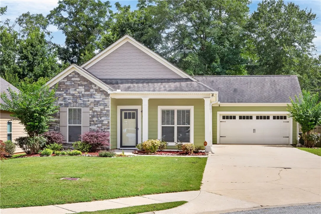 A well-maintained single-story home with inviting curb appeal features a blend of stone and siding.