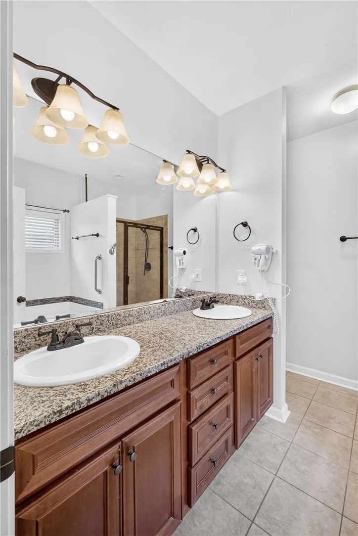 Double vanities with granite counters define this well-appointed primary bathroom.