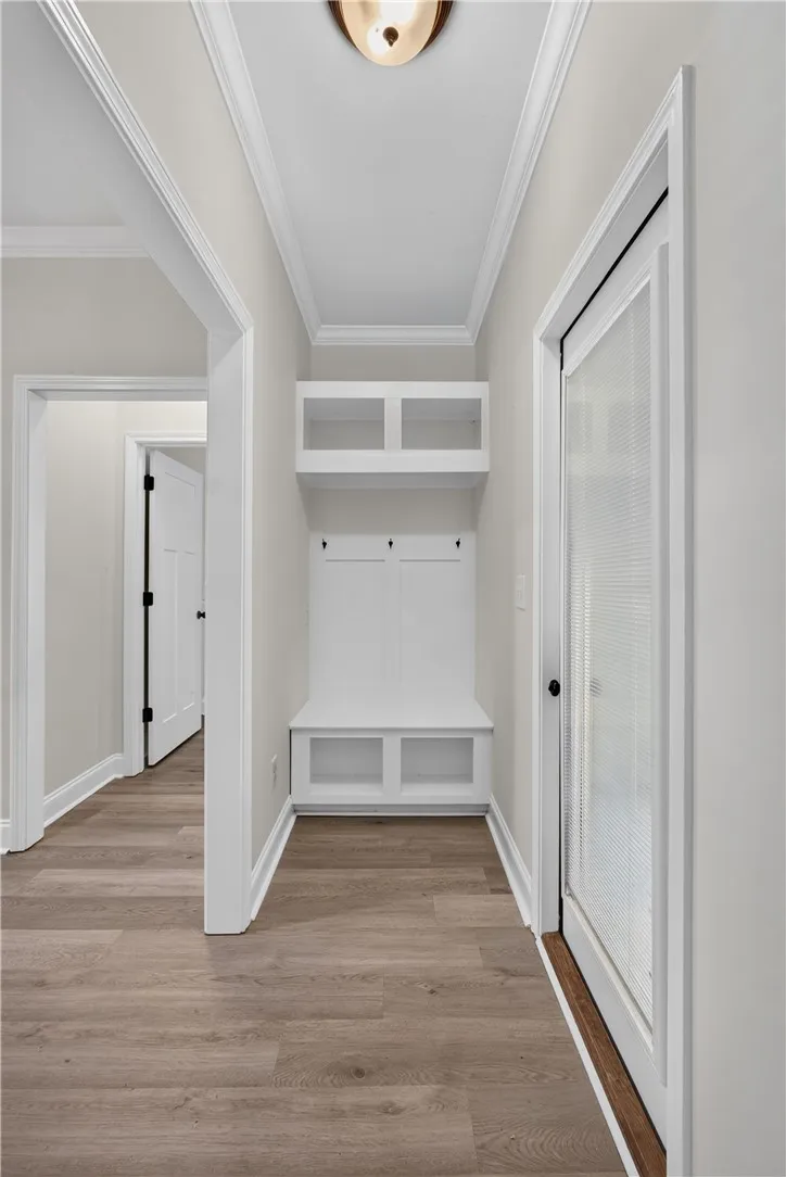 A well-appointed coat nook features a built-in bench with hooks and cubbies for convenient storage.