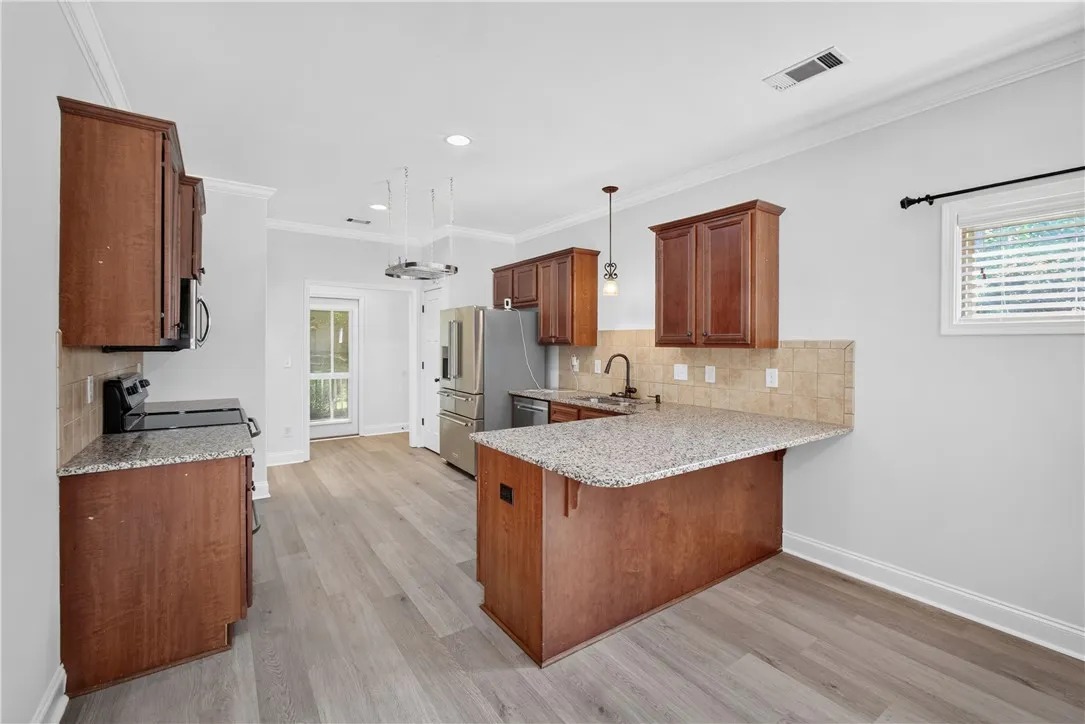 Granite counters and rich wood cabinetry define this modern, well-appointed kitchen.