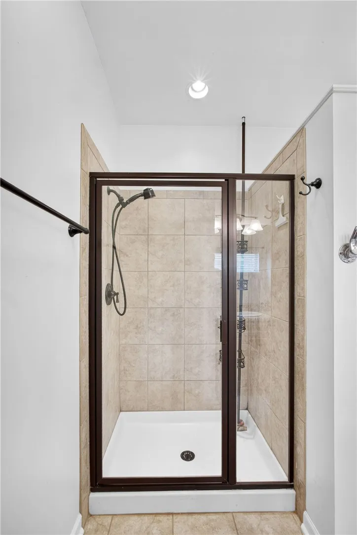 A well-appointed shower stall features tiled walls and a glass enclosure, offering a refreshing bathing experience.