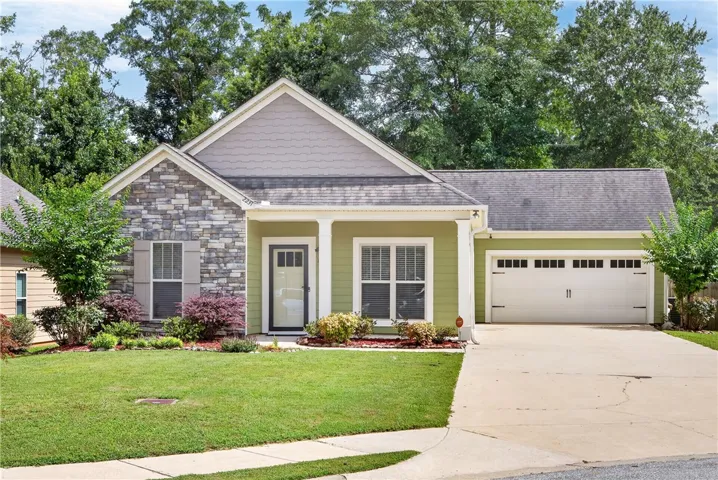 A well-maintained single-story home with inviting curb appeal features a blend of stone and siding.