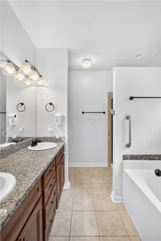 Granite counters and dual sinks define this bright, well-appointed primary bathroom.