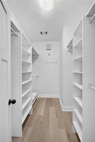 A well-organized walk-in closet featuring built-in shelving and ample storage space.