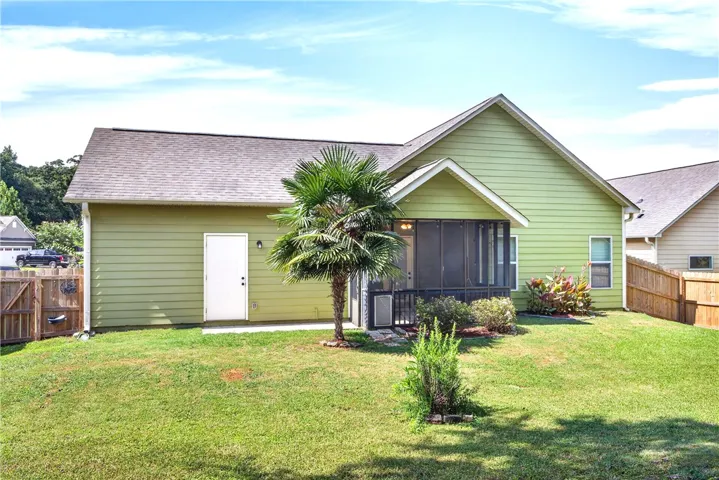A vibrant green exterior and lush backyard create a serene outdoor living space.
