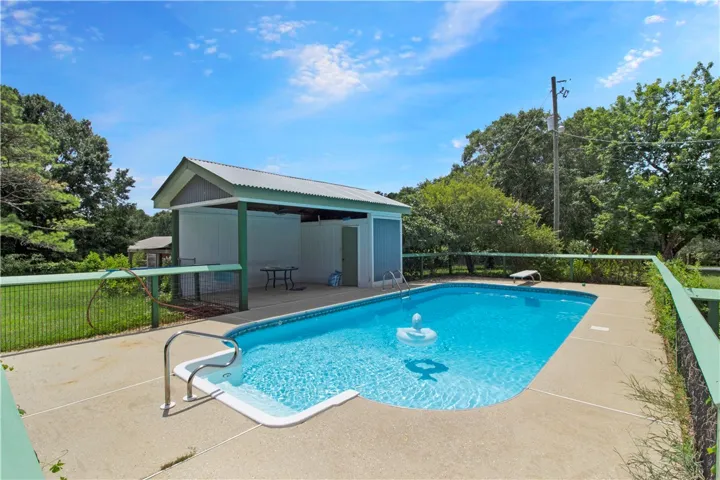 An inviting backyard oasis offers a sparkling in-ground pool and a convenient poolside changing room.