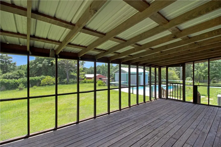 Enjoy idyllic countryside views and a sparkling pool from this expansive screened-in porch.