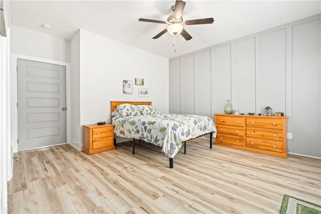 Primary Bedroom with accent wall and LVP floors