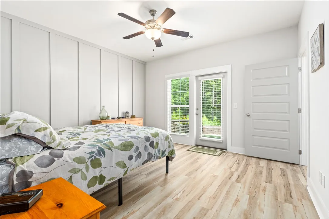 Primary Bedroom with accent wall and LVP floors