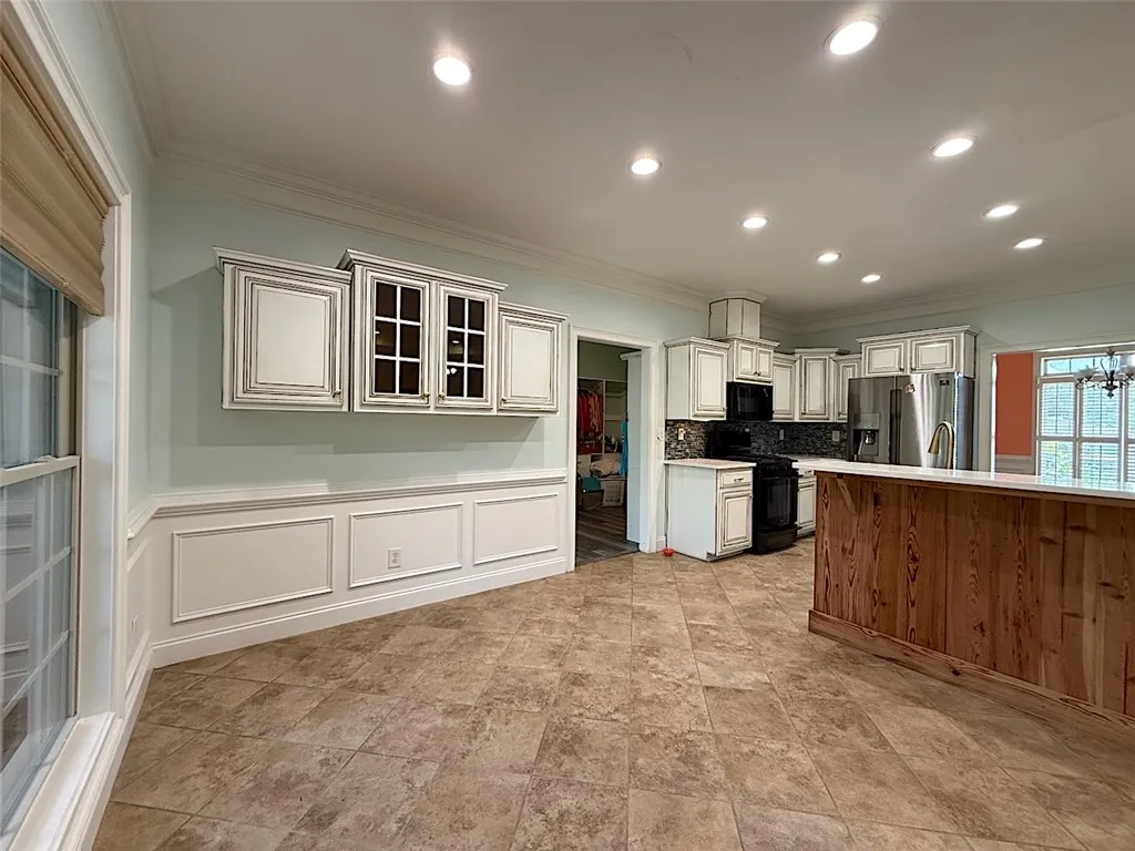 A welcoming kitchen space offers ample cabinetry and recessed lighting.