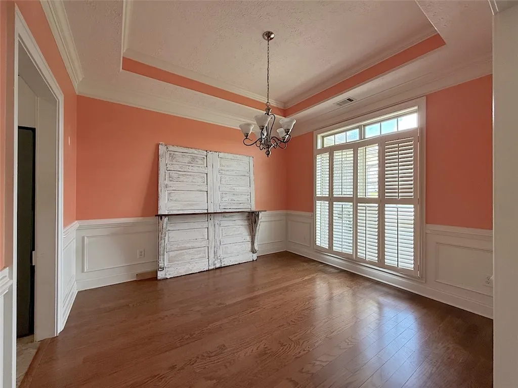 Elegant crown molding and rich hardwood flooring create a sophisticated dining space.