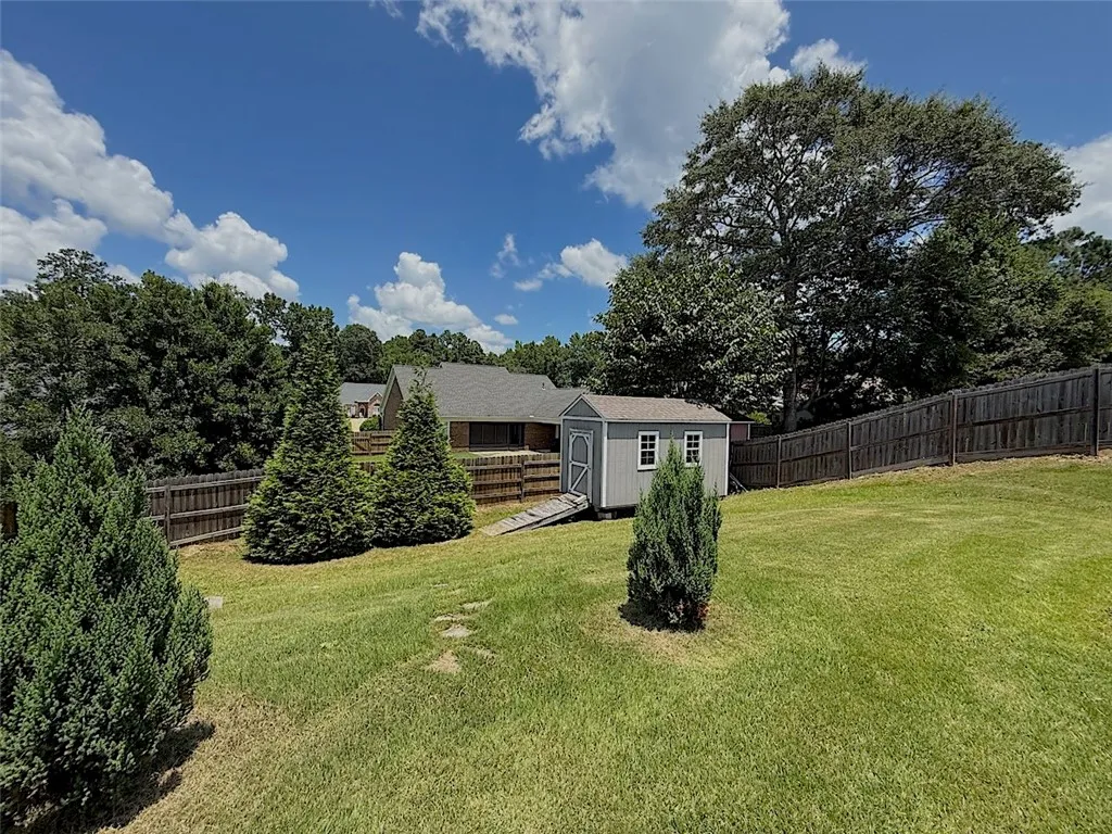 A well-maintained yard provides ample space for recreation, complete with mature trees and a functional storage shed.