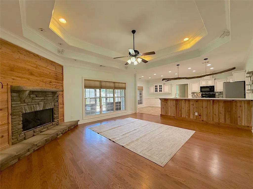 A spacious common area offers gleaming hardwood floors and a striking stone fireplace, perfect for gatherings.