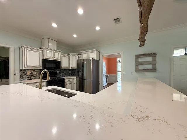 Culinary delights await in this modern kitchen, featuring pristine countertops and ample cabinetry.