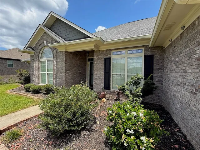 A classic brick exterior with tasteful landscaping offers a welcoming entry.