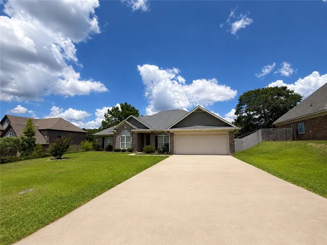 A well-maintained lawn and a long driveway lead to this charming brick and siding residence.