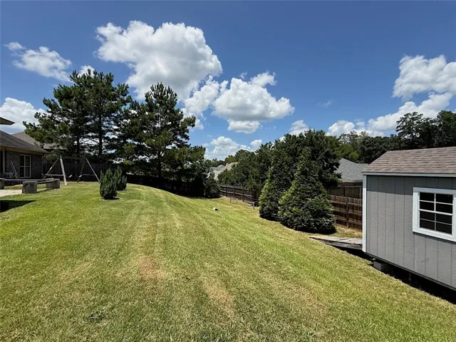 A generously sized yard, complete with a storage shed and mature trees, offers ample space for outdoor enjoyment.