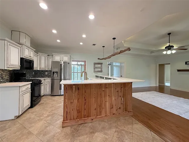 A well-appointed kitchen island with warm wood paneling creates a natural focal point within this open-concept living space.