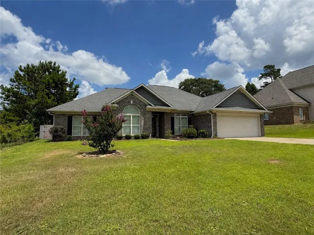 A well-maintained lawn and mature landscaping enhance this inviting brick and siding residence.