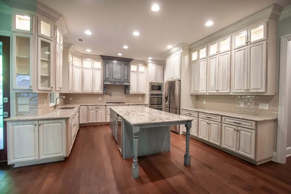 An inviting kitchen with rich hardwood floors, an elegant stone island, and extensive cabinetry for culinary pursuits.