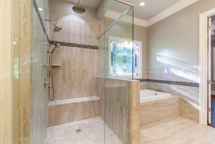 A spacious primary bathroom with a walk-in shower, soaking tub, and elegant tile work.