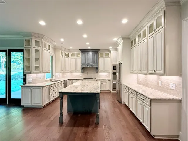 A beautiful kitchen features a central island, rich hardwood flooring, and ample counter space for culinary pursuits.